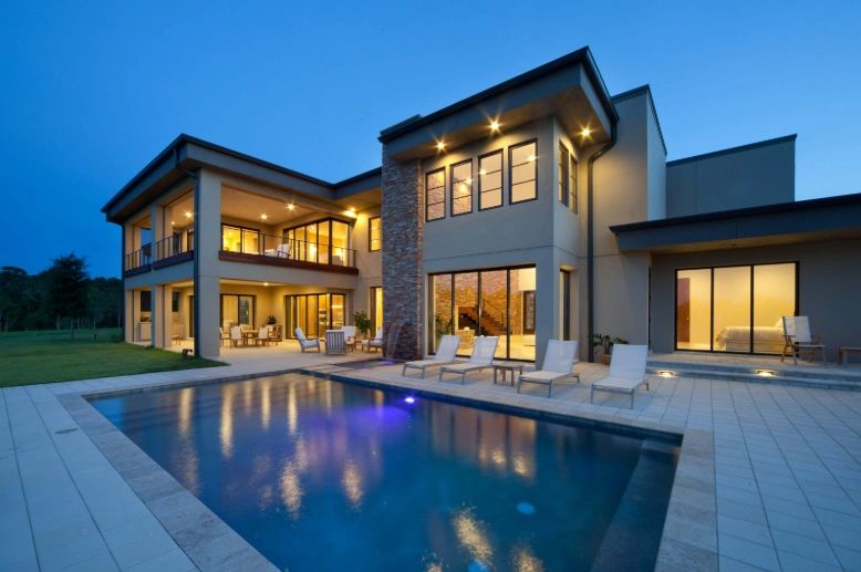 Modern two-story new construction home with pool at dusk in Tampa Bay